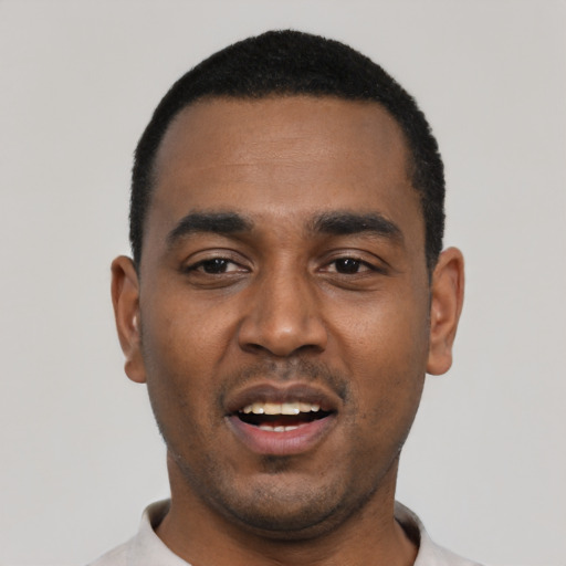 Joyful black young-adult male with short  black hair and brown eyes