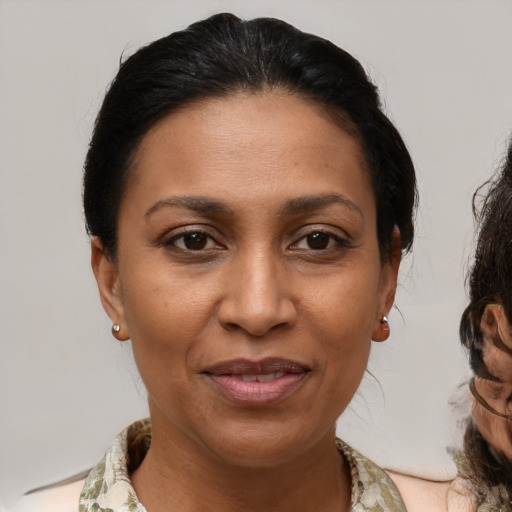 Joyful latino adult female with medium  brown hair and brown eyes
