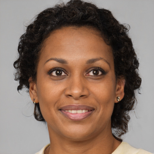 Joyful black adult female with short  brown hair and brown eyes