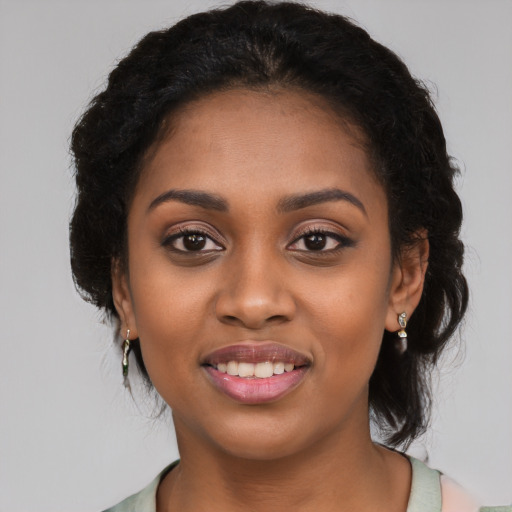 Joyful black young-adult female with long  black hair and brown eyes