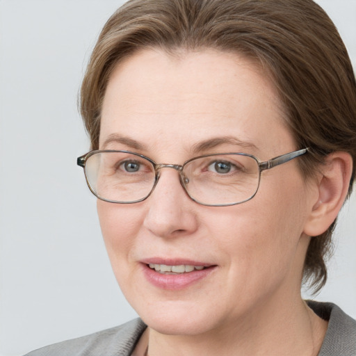 Joyful white adult female with medium  brown hair and grey eyes