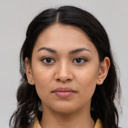 Joyful latino young-adult female with long  brown hair and brown eyes