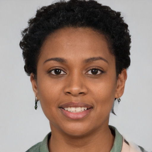 Joyful black young-adult female with short  black hair and brown eyes