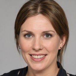 Joyful white young-adult female with medium  brown hair and grey eyes