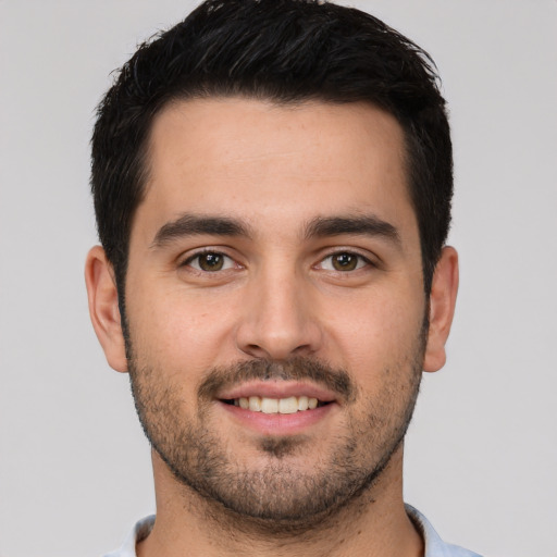 Joyful white young-adult male with short  black hair and brown eyes