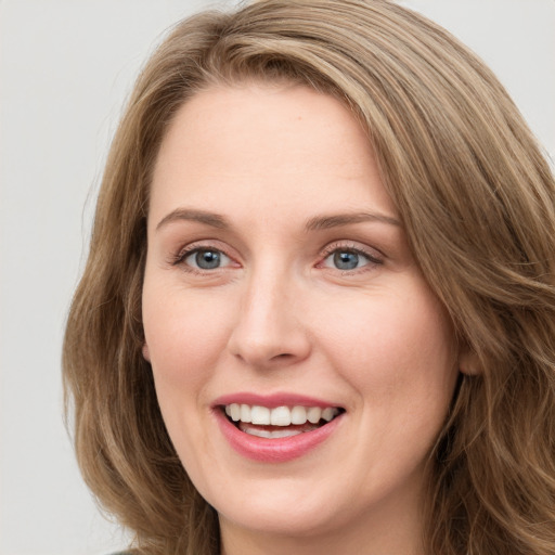 Joyful white young-adult female with long  brown hair and green eyes