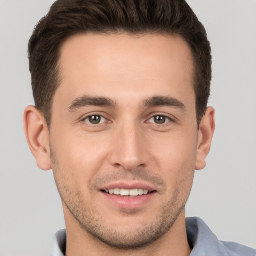 Joyful white young-adult male with short  brown hair and brown eyes