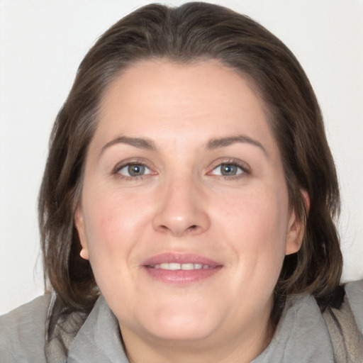 Joyful white adult female with medium  brown hair and blue eyes