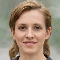 Joyful white young-adult female with medium  brown hair and grey eyes