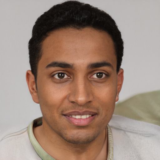 Joyful latino young-adult male with short  black hair and brown eyes