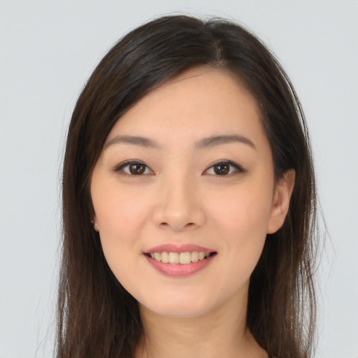 Joyful asian young-adult female with long  brown hair and brown eyes