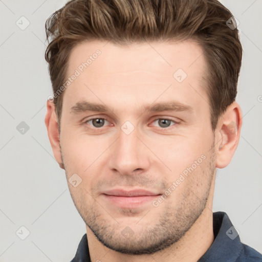 Joyful white young-adult male with short  brown hair and grey eyes