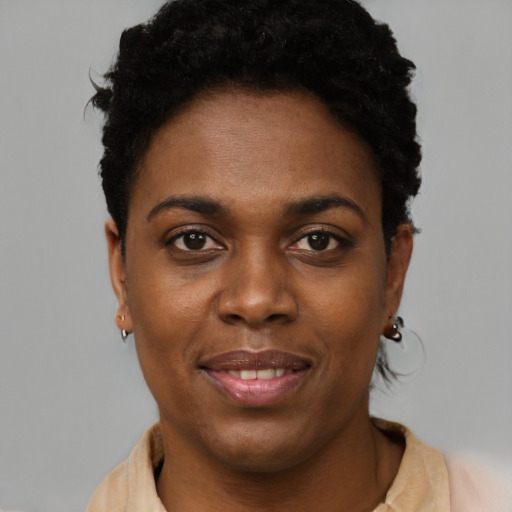 Joyful black young-adult female with short  brown hair and brown eyes