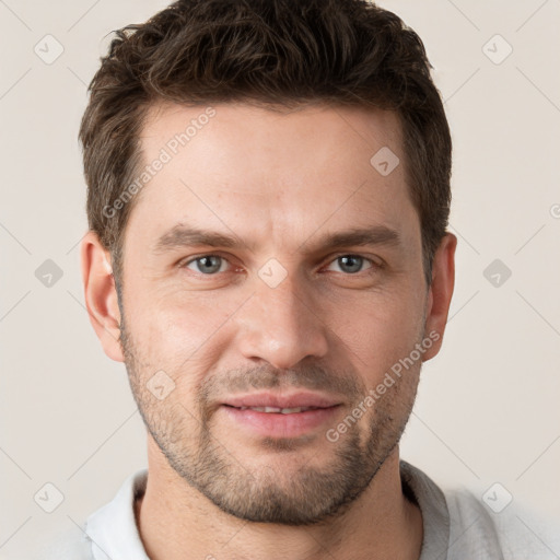 Joyful white young-adult male with short  brown hair and grey eyes