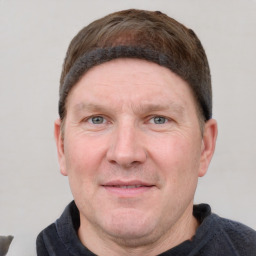 Joyful white adult male with short  brown hair and grey eyes