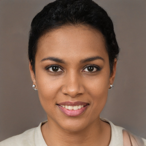 Joyful black young-adult female with short  black hair and brown eyes