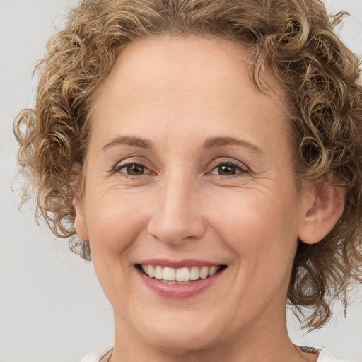 Joyful white adult female with medium  brown hair and green eyes