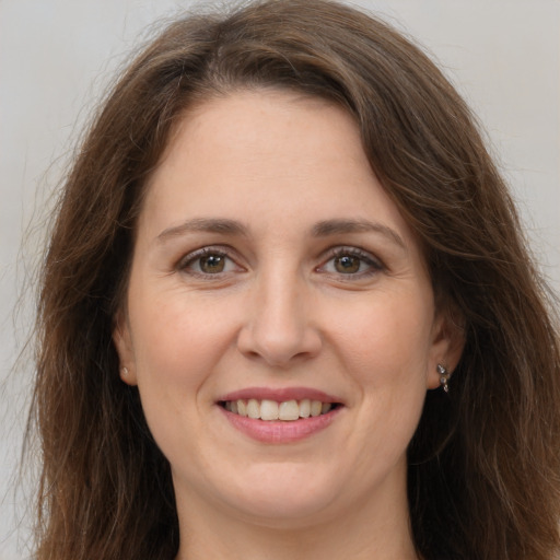 Joyful white young-adult female with long  brown hair and grey eyes