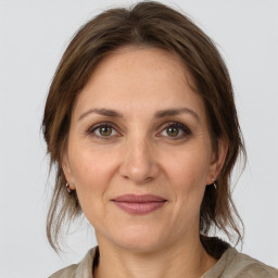 Joyful white adult female with medium  brown hair and grey eyes