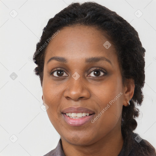 Joyful black young-adult female with long  brown hair and brown eyes