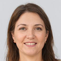 Joyful white adult female with long  brown hair and grey eyes