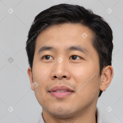 Joyful asian young-adult male with short  brown hair and brown eyes