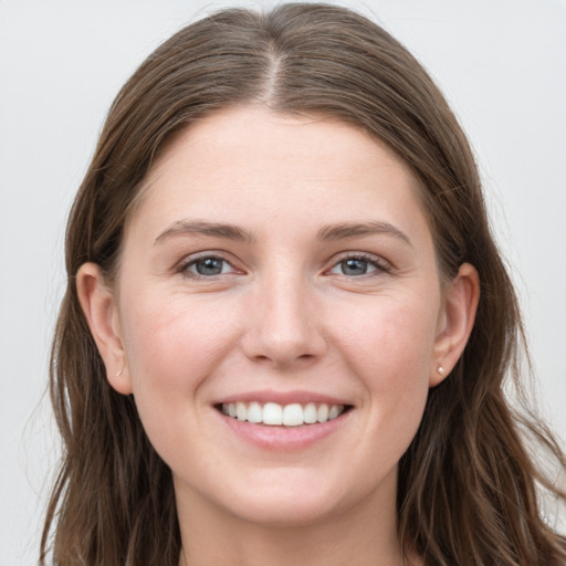 Joyful white young-adult female with long  brown hair and grey eyes