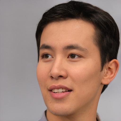Joyful asian young-adult male with short  brown hair and brown eyes