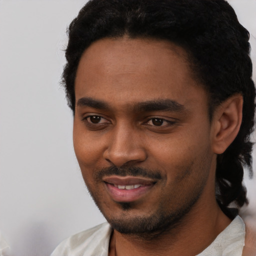 Joyful black young-adult male with short  black hair and brown eyes