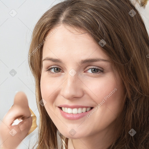 Joyful white young-adult female with long  brown hair and grey eyes