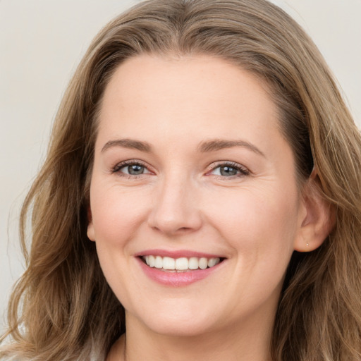 Joyful white young-adult female with long  brown hair and grey eyes