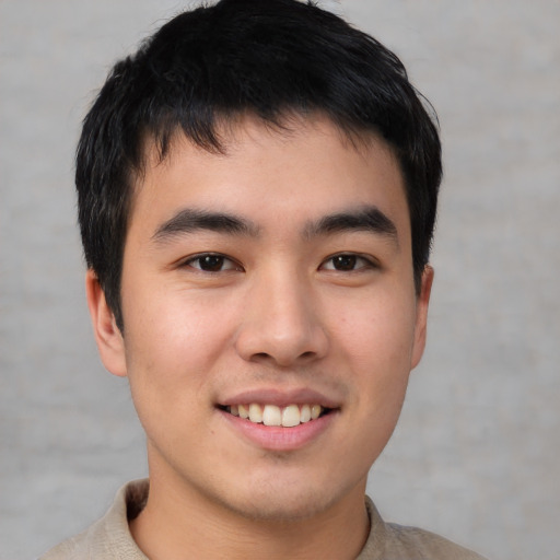 Joyful asian young-adult male with short  brown hair and brown eyes