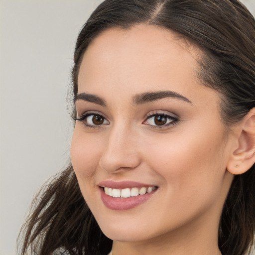 Joyful white young-adult female with long  brown hair and brown eyes