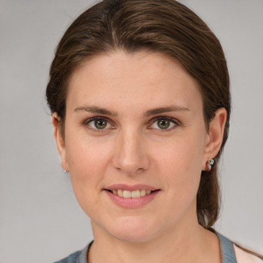 Joyful white young-adult female with medium  brown hair and grey eyes