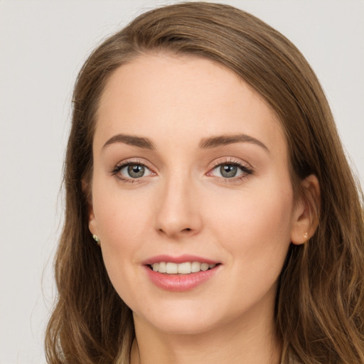 Joyful white young-adult female with long  brown hair and grey eyes