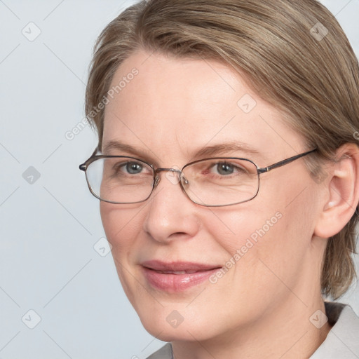 Joyful white adult female with medium  brown hair and blue eyes