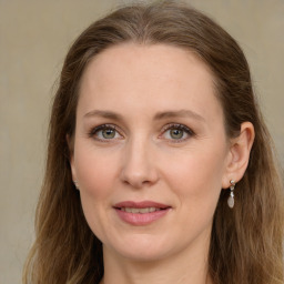 Joyful white adult female with long  brown hair and green eyes