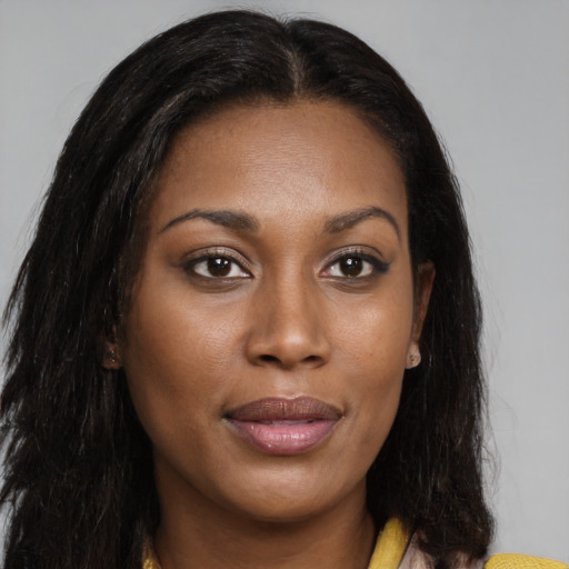 Joyful black young-adult female with long  brown hair and brown eyes