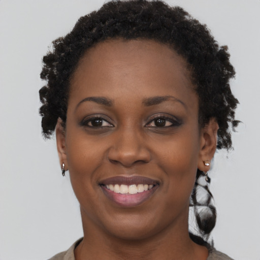 Joyful black young-adult female with short  brown hair and brown eyes