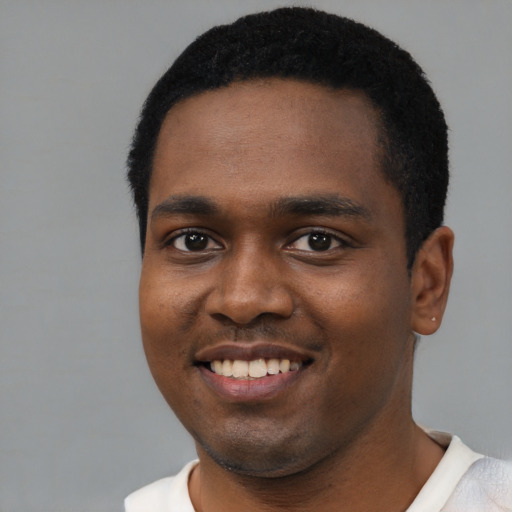 Joyful black young-adult male with short  black hair and brown eyes