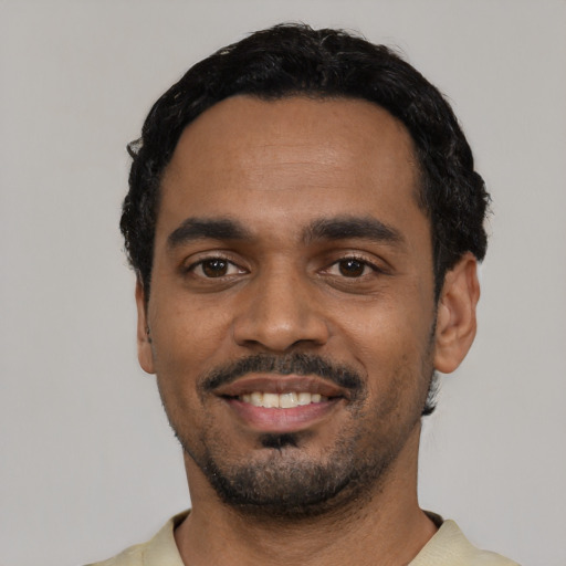 Joyful black young-adult male with short  black hair and brown eyes