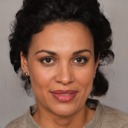 Joyful latino adult female with medium  brown hair and brown eyes