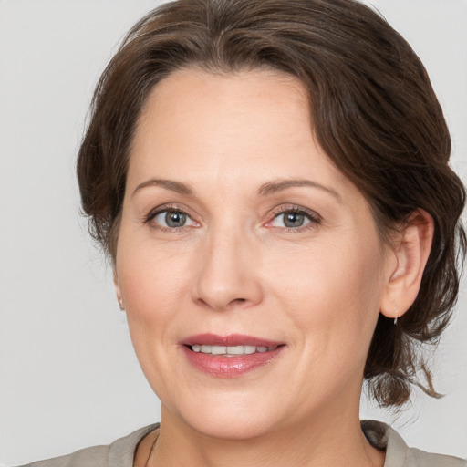 Joyful white adult female with medium  brown hair and grey eyes