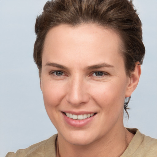 Joyful white young-adult female with short  brown hair and grey eyes