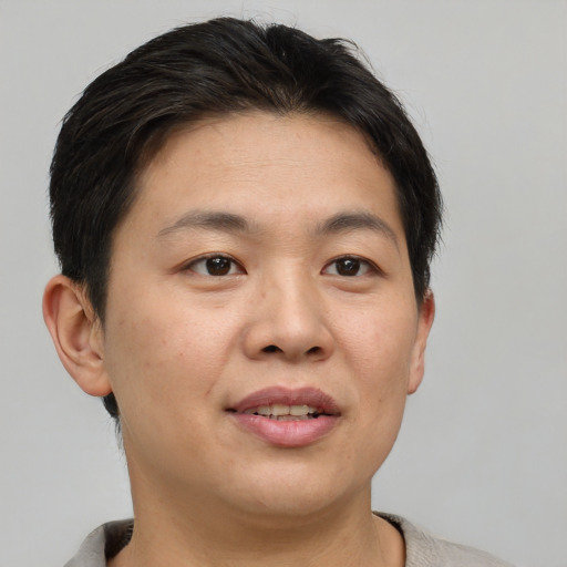 Joyful asian adult female with short  brown hair and brown eyes