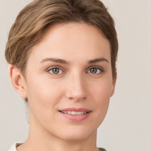 Joyful white young-adult female with short  brown hair and grey eyes