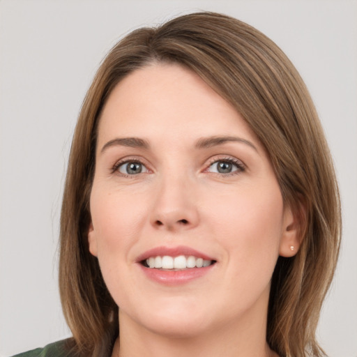 Joyful white young-adult female with medium  brown hair and green eyes