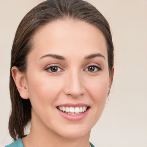 Joyful white young-adult female with medium  brown hair and grey eyes