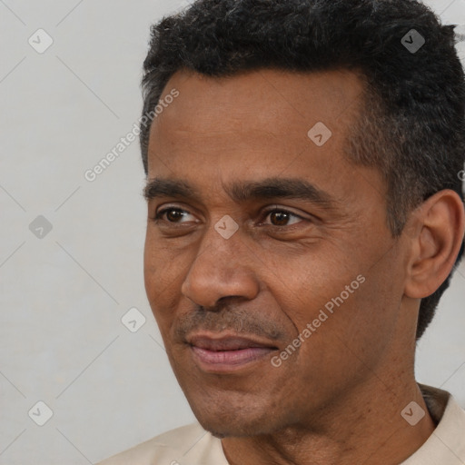 Joyful black adult male with short  black hair and brown eyes