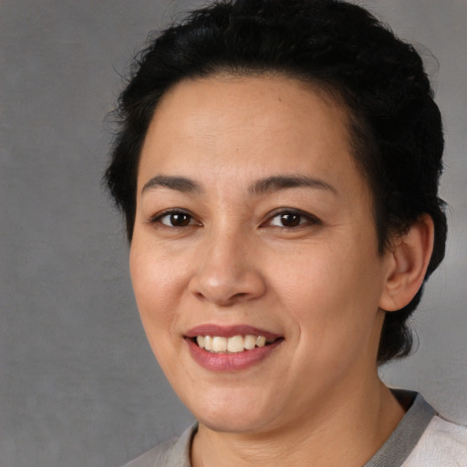 Joyful latino young-adult female with short  black hair and brown eyes